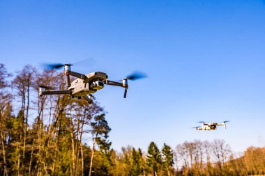 Graz, Avusturya 15.03.2020 - DJI Drones Maviç mini ve Mavic 2 Pro birlikte uçuyorlar. Boyut farkı. Mavi gökyüzüne karşı. Boşluğu kopyala