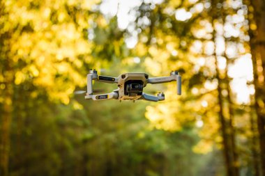 Graz, Avusturya: 02.01.2020 - Bir Dji Quadcopter Drone Mavic mini 249g 'un yakın plan çekimi. Güneşli ormanda uçan insansız hava aracı. Dji insansız hava araçları ve hava fotoğrafçılık sistemlerinde pazar lideri..