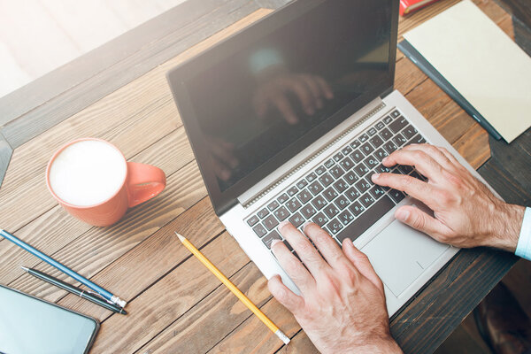 Male hands typing on laptop keyboard, mockup