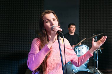 Kadın solist mikrofona şarkı