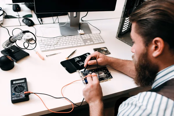 Bearded engineer testing microcircuit — Stock Photo, Image