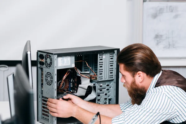 Reparador barbudo desmontando unidade de computador — Fotografia de Stock