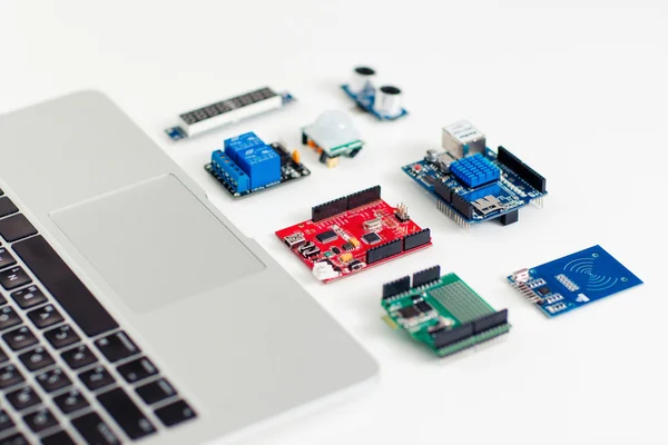 Componentes eletrônicos coloridos perto do laptop — Fotografia de Stock