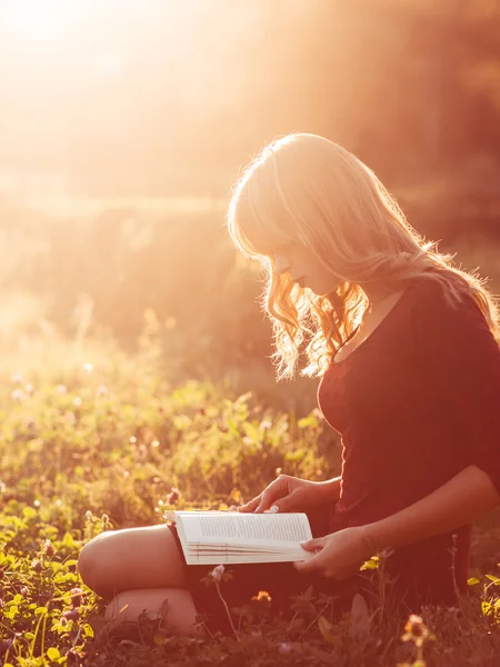 Hermosa mujer leyendo libro en la naturaleza, destello del sol —  Fotos de Stock