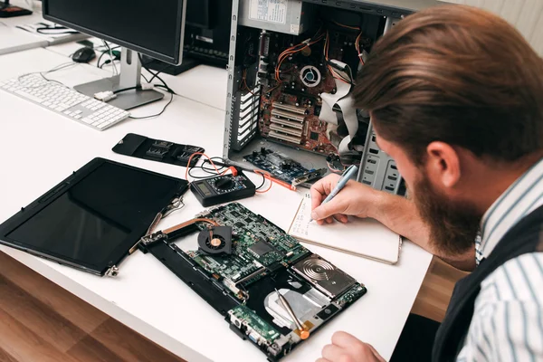 Bearded programmer inspecting computer motherboard — Stock Photo, Image