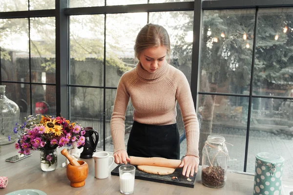 Jeune femme dérouler la pâte dans la cuisine — Photo