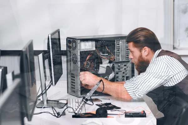 Repairman fixing computer, double exposure