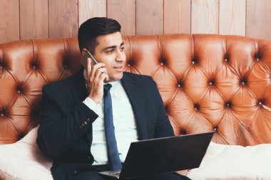Mutlu iş adamı telefonda konuşuyor.
