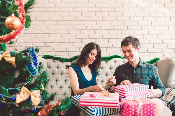 Uomo e donna sorridente imballaggio regali, spazio libero — Foto Stock