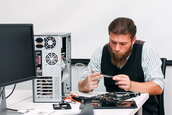 Repairman examine inside part of computer — Stock Photo, Image