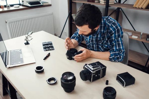 Фотограф розбирає фотоапарат на робочому місці — стокове фото