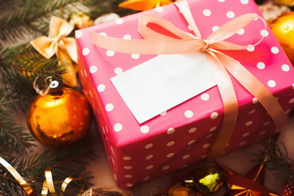 Caja de regalo rosa con tarjeta en blanco bajo el árbol de Navidad —  Fotos de Stock