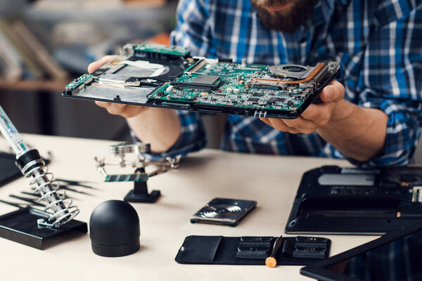 Engineer studying computer motherboard, close-up