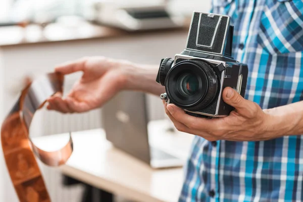 Fotograaf permanent met retro camera en film — Stockfoto