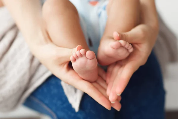 Säuglingsbeine in den Händen der Mutter, Nahaufnahme — Stockfoto