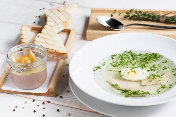 Bouillon met ei en ganzenlever op tafel — Stockfoto