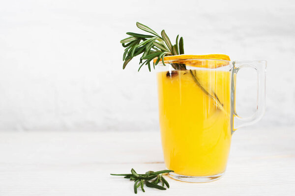 Апельсиновый сок с розмарином на белом фоне
