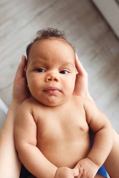 Afrikkalainen vastasyntynyt lapsi äidin käsissä ylhäältä — kuvapankkivalokuva
