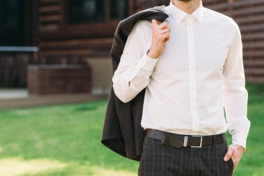 Takım elbise ceket omzunun üzerinden, boş alan tutan adam