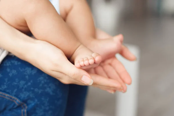 Madre sosteniendo las piernas de un bebé pequeño, espacio libre —  Fotos de Stock