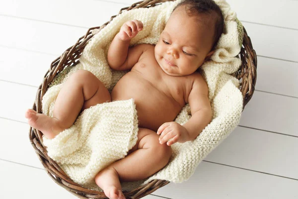 Newborn african baby in wicker basket, flat lay — Stock Photo, Image
