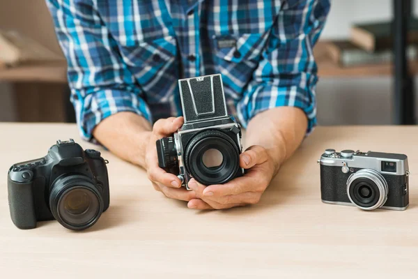 Hombre sosteniendo la cámara de fotos de película en las manos —  Fotos de Stock