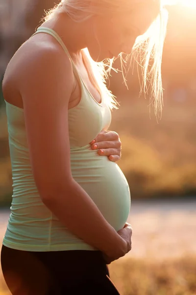 A terhes nő hasára átölelve profilja — Stock Fotó