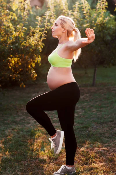 Giovane donna incinta che esercita all'aperto — Foto Stock