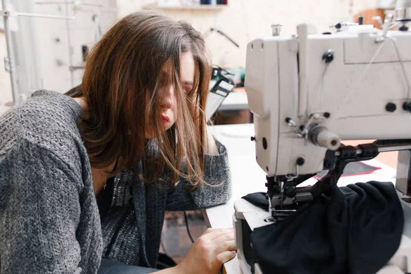 Tailleur fatigué assis près de la machine à coudre — Photo