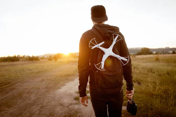 Mladý muž s DRONY jít do západu slunce, volného prostoru — Stock fotografie