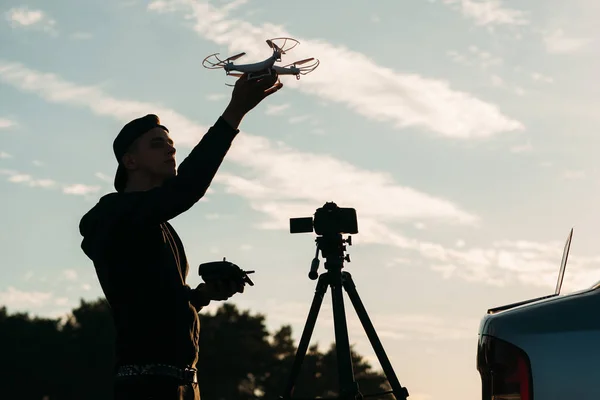 Man playing with drone, silhouette at sunset sky — Stock Photo, Image