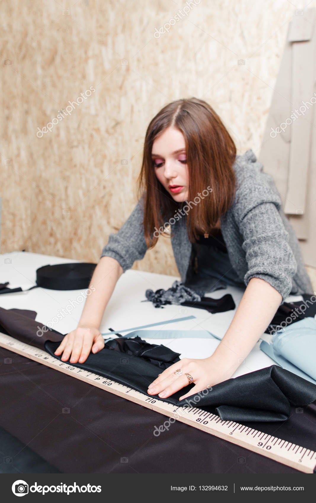 Female Fashion Designer Measuring and Cutting Fabric before Sewing