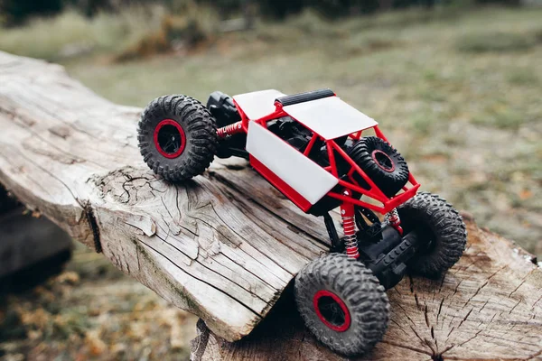 Rc car overcoming wooden log, free space — Stock Photo, Image