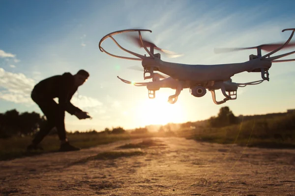 Piloto correndo drone ao pôr do sol luz, espaço livre — Fotografia de Stock