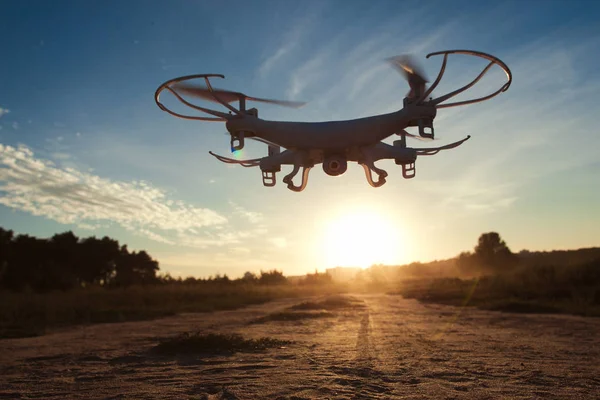 Drone voando ao ar livre à noite, fundo do pôr do sol — Fotografia de Stock