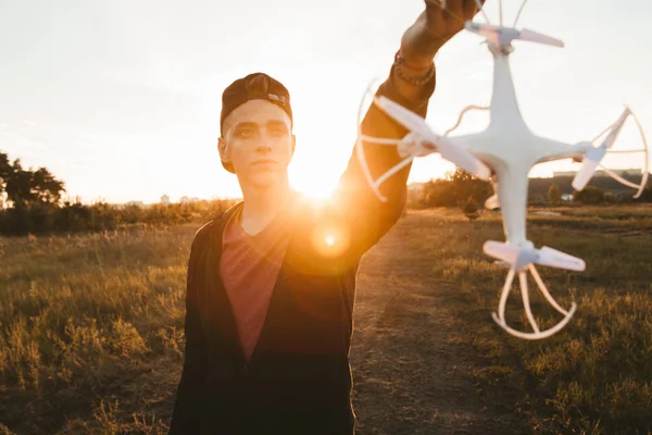 Hombre sosteniendo el dron para la hélice, la llamarada del atardecer — Foto de Stock