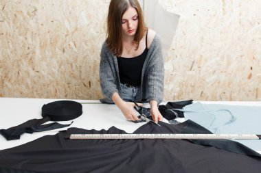 Genç kadın atölye siyah kumaş kesme