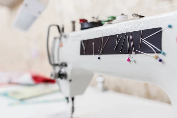 Naaimachine met kleurrijke naalden op workshop — Stockfoto