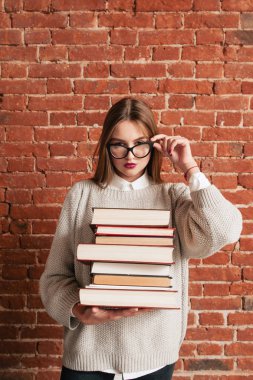 Seksi öğrenci kitaplarla gözlüklerle bakıyor