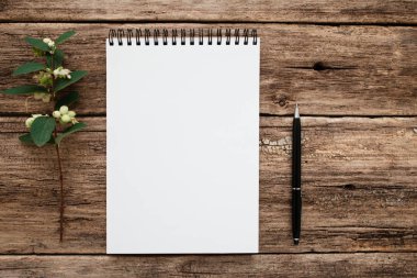 Boş beyaz defter ile çiçek ve kalem düz yatıyordu