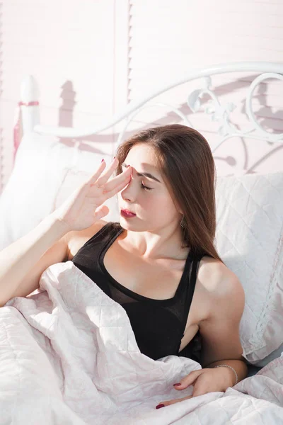 Mujer joven en la cama con retrato de dolor de cabeza —  Fotos de Stock