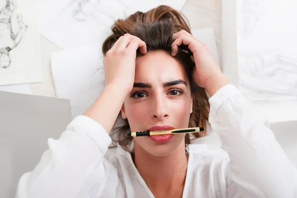 Geschokt vrouw kijken camera met potlood in mond — Stockfoto