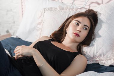 Düşünceli kadın yatakta, boş alan