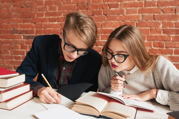 Par de estudantes lendo cuidadosamente o livro didático — Fotografia de Stock