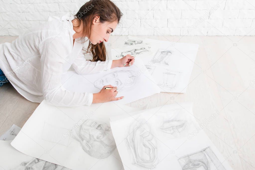 Successful woman artist drawing in workshop