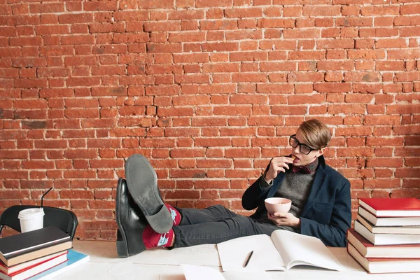 Exhausted student having snack at desk, free space — Stock Photo, Image