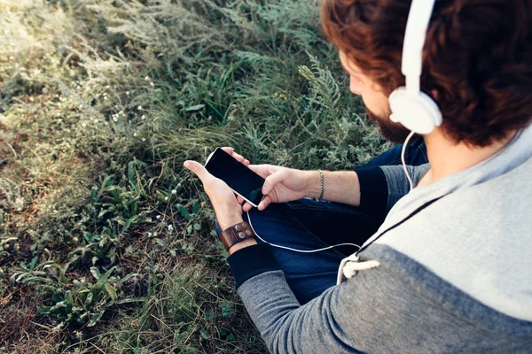 Man väljer musik på smartphone utomhuspool — Stockfoto