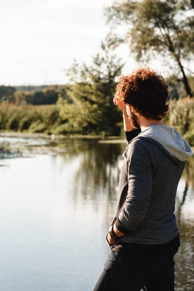 Joven chico elegante disfrutando de un paisaje tranquilo en el río — Foto de Stock