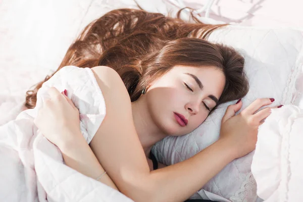 Hermosa mujer durmiendo en una cama acogedora — Foto de Stock