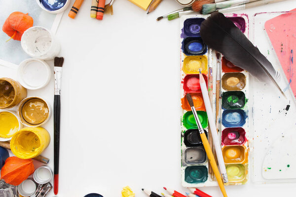 Палитра гуашь и акварель на белом столе
